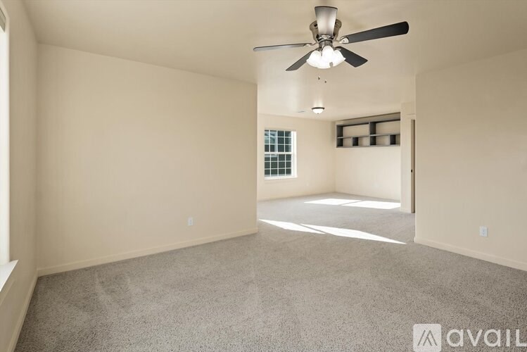 A spacious room with a ceiling fan and a window.
