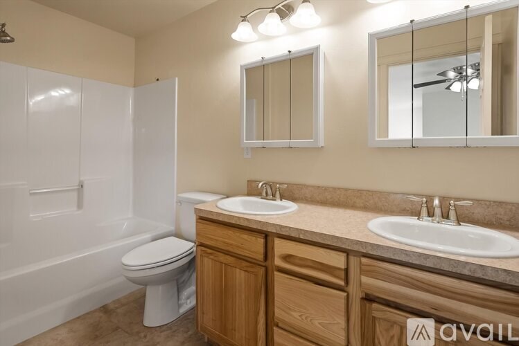 A bathroom with a toilet, sink, and mirror.