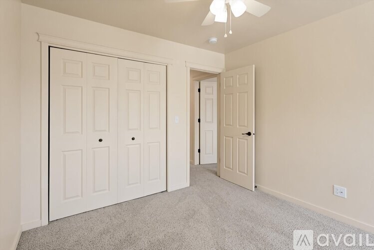 A room with two doors and a carpeted floor.