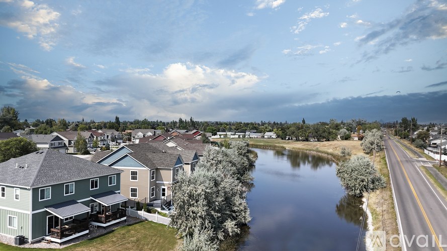 A river flows through a residential area with houses on both sides.