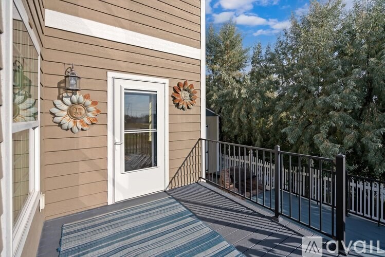 A deck with a white door and two flower decorations on the wall.