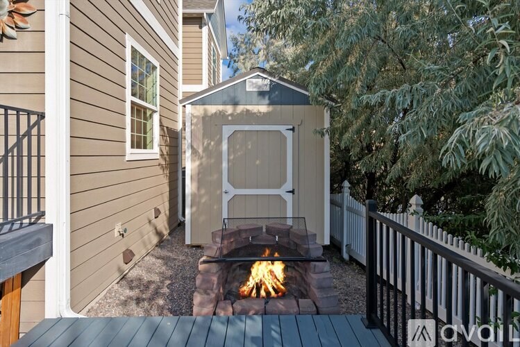 A backyard with a fire pit and a shed.