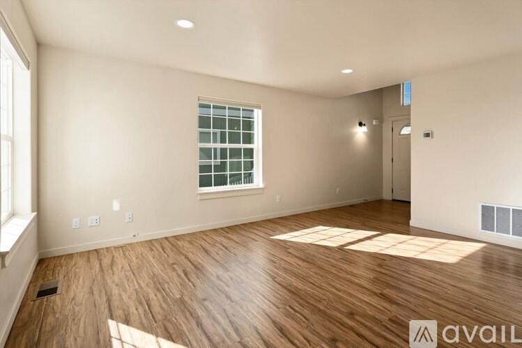 A room with wooden flooring and a window with a grid of glass panes.