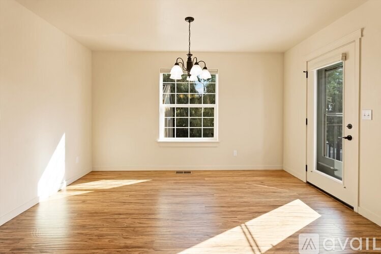 A room with wooden floors and a chandelier.