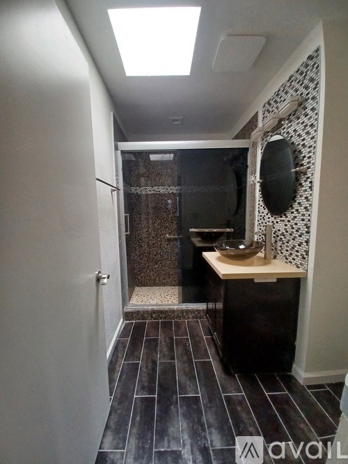 A bathroom with a shower and sink.