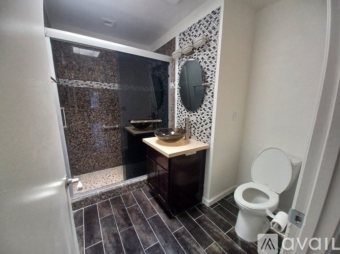 A bathroom with a toilet, sink, and shower.
