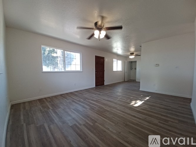 A room with wooden flooring and a ceiling fan.