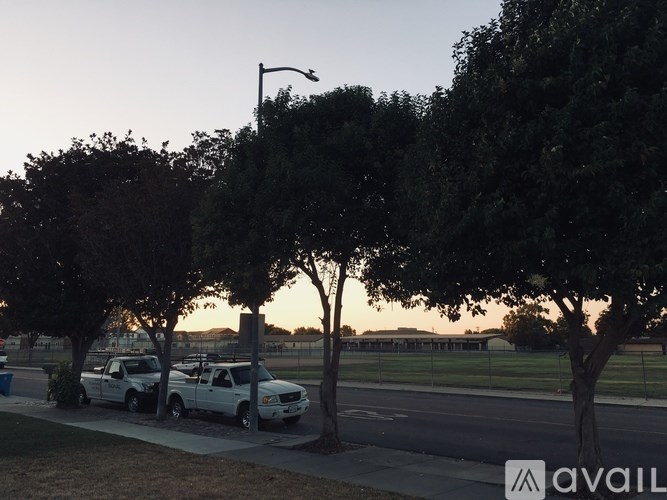 Two white cars parked on the side of a road.