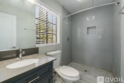 A bathroom with a toilet, sink, and shower.