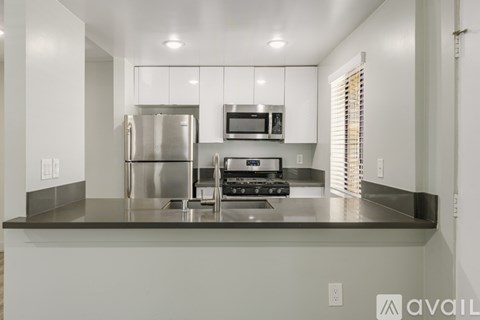 A modern kitchen with stainless steel appliances and white cabinets.