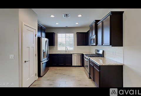 A kitchen with dark brown cabinets and a white door.