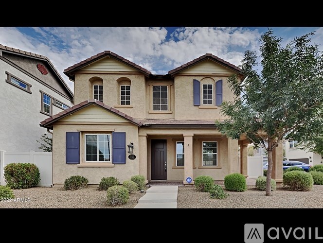 A house with a brown roof and blue shutters is for sale.