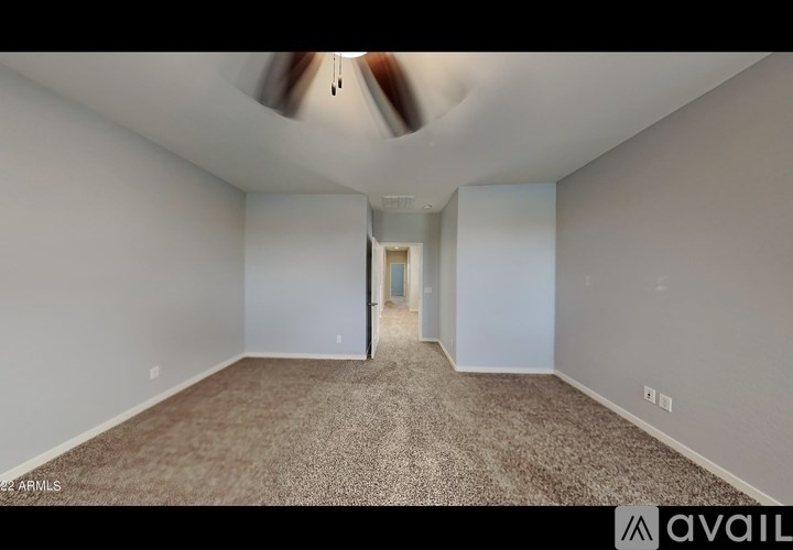 A spacious room with a carpeted floor and a door at the end.