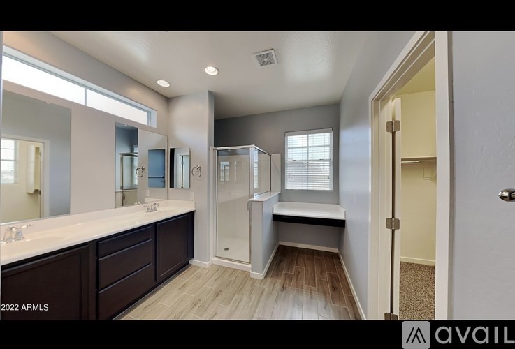 A bathroom with a walk-in shower and double sinks.
