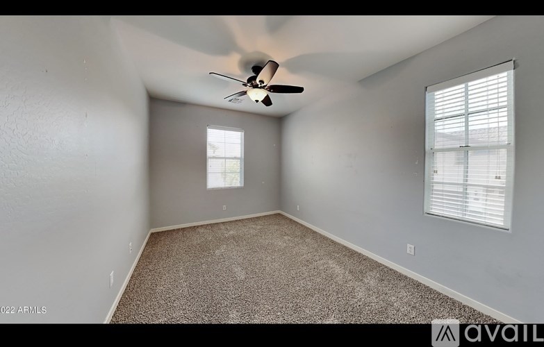 A room with a ceiling fan and carpeted floor.
