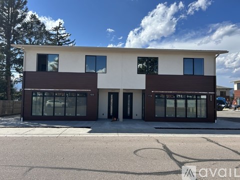 A modern two-story building with a white and brown facade is available for rent.