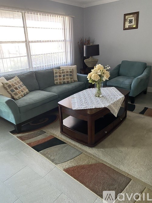 A living room with a couch, a coffee table, and a lamp.