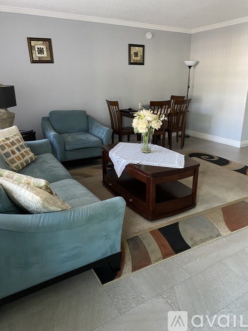 A living room with a blue couch, a wooden coffee table, and a rug.