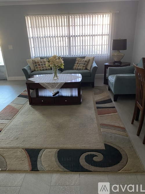A living room with a couch, chairs, and a coffee table.