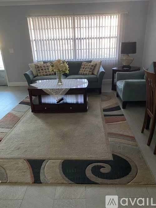 A living room with a couch, chairs, and a coffee table.
