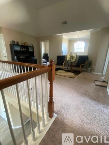 A living room with a television, two chairs, and a table.