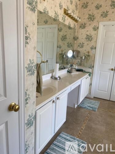 A bathroom with a floral wallpaper and a sink.