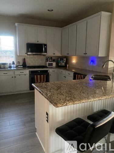 A kitchen with granite countertops and white cabinets.
