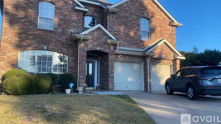 A brick house with a car parked in front.