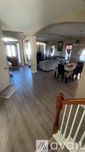 A living room with a couch, chairs, and a dining table.