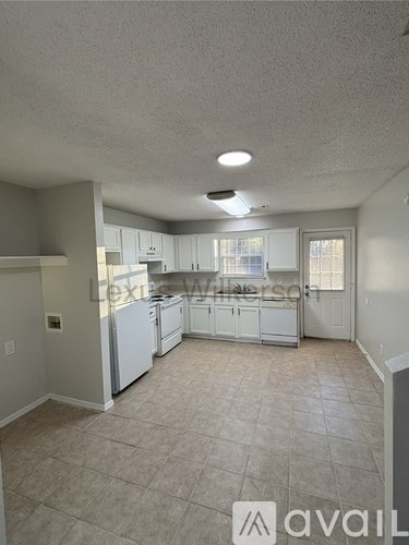 A kitchen with white appliances and cabinets.