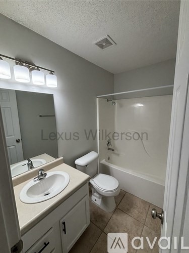 A bathroom with a toilet, sink, and mirror.