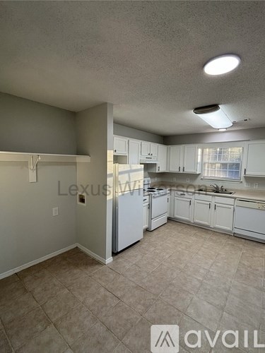A kitchen with white cabinets and a tiled floor.