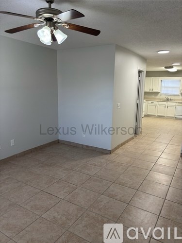 A room with a ceiling fan and tiled flooring.