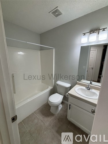 A bathroom with a toilet, sink, and bathtub.