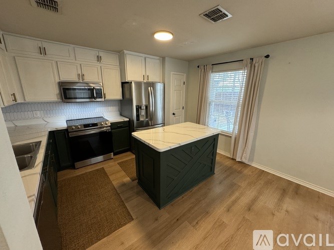 A kitchen with a refrigerator, oven, and microwave.