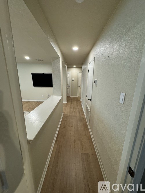 A long hallway with a TV mounted on the wall.