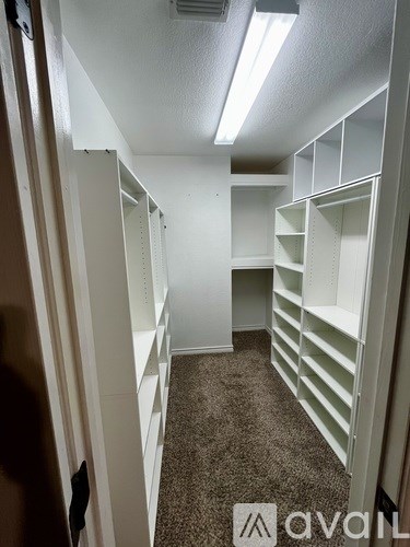 A long hallway with white shelves on the side.