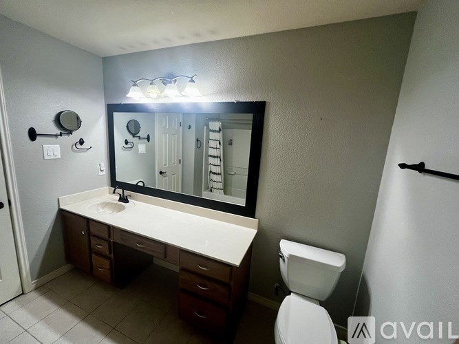A bathroom with a white sink and a toilet.