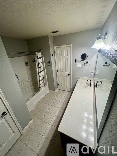 A bathroom with a white sink and a white door.