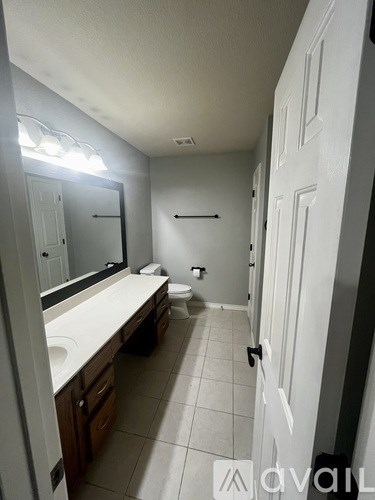 A bathroom with a sink, mirror, and toilet.