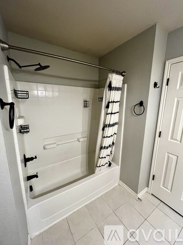 A white bathroom with a walk-in shower and a white door.