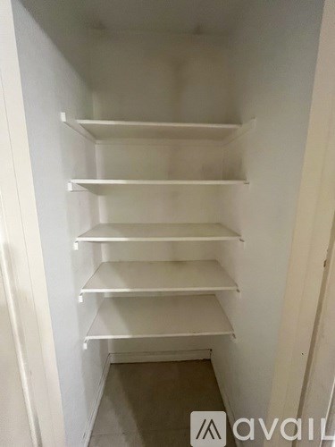 Empty white shelves in a narrow hallway.