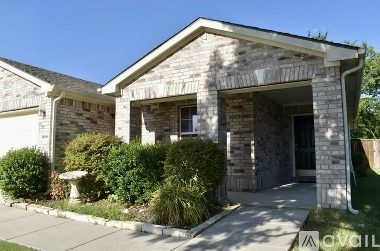 A house with a stone facade and a front yard with a fountain.