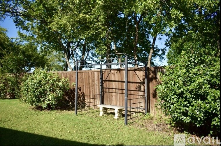 A wooden fence with a bench in front of it.
