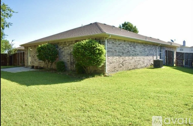 A house with a stone wall and a green lawn.