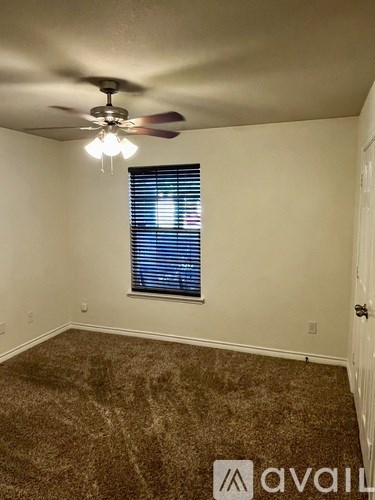 A room with a ceiling fan and a window with blinds.