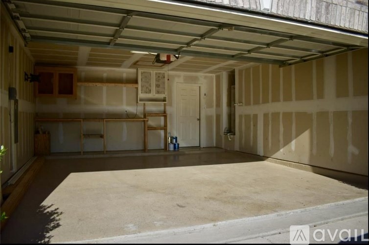 A large, empty garage with a concrete floor and walls covered in insulation.
