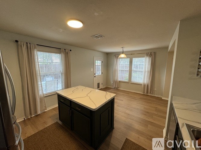 A kitchen with a white countertop and black cabinets.