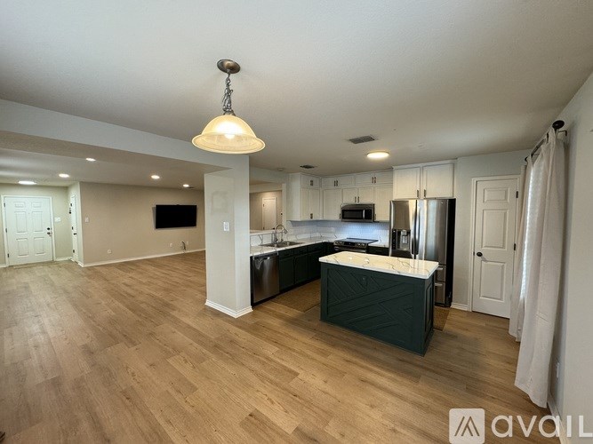A kitchen with a wooden floor and white walls.