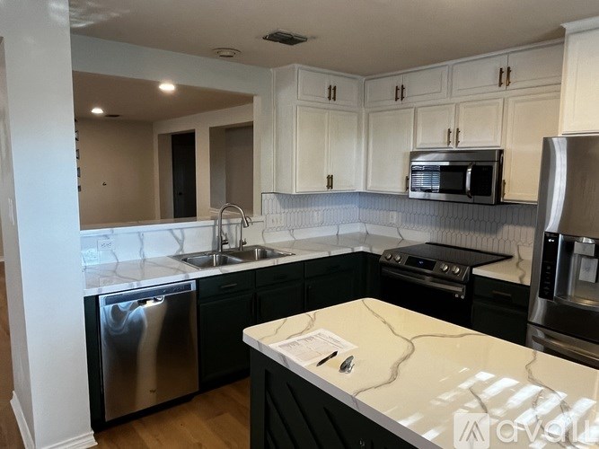 A kitchen with black countertops and white cabinets.